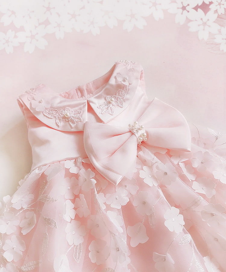 Pink dress with floral details and a large bow on a light pink background bleuribbon