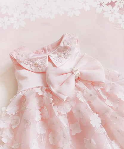Pink dress with floral details and a large bow on a light pink background bleuribbon
