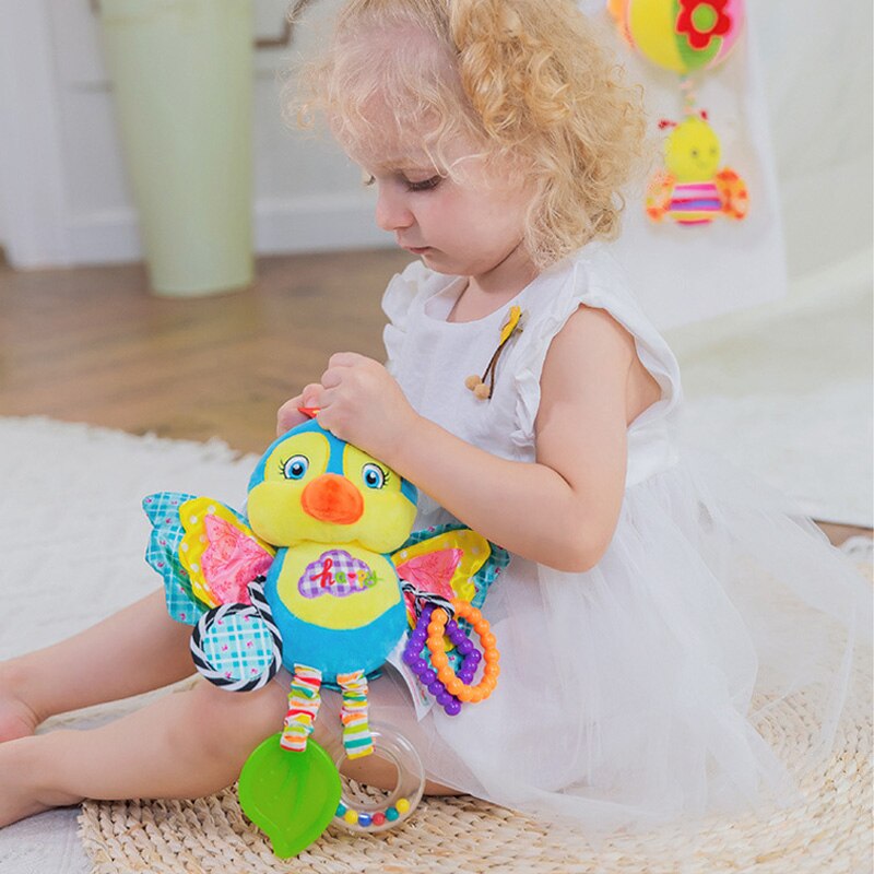 Child playing with a colorful butterfly toy on a light-colored rug. blue ribbon baby