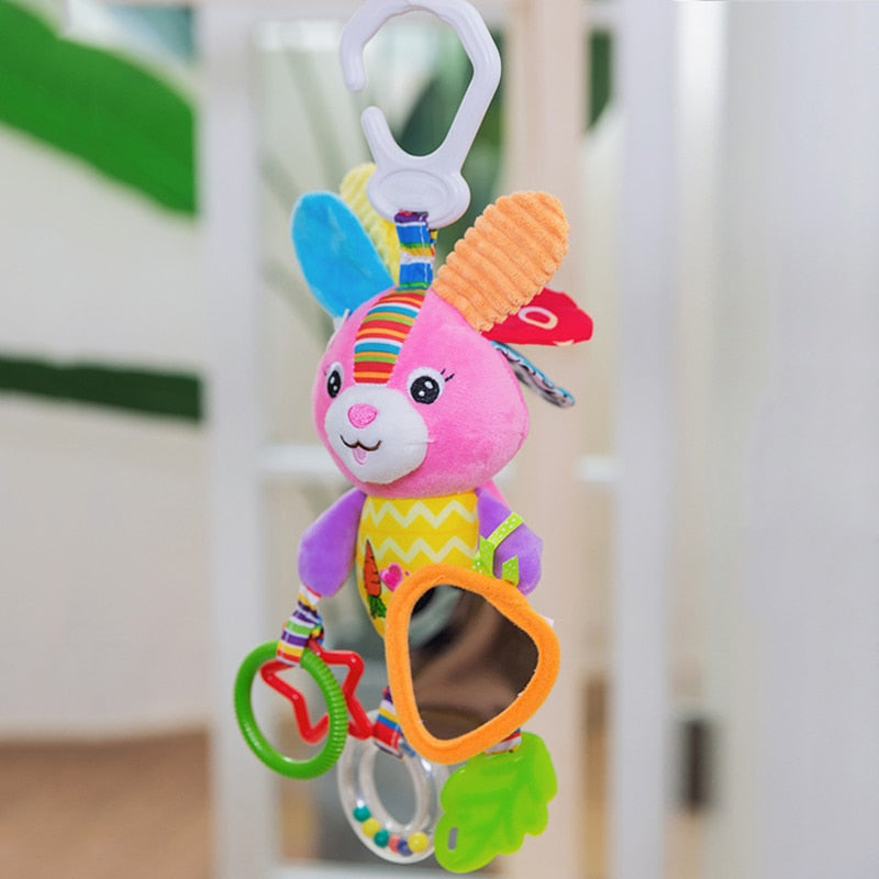 Colorful baby toy with a rabbit design hanging against a blurred indoor background bleu ribbon