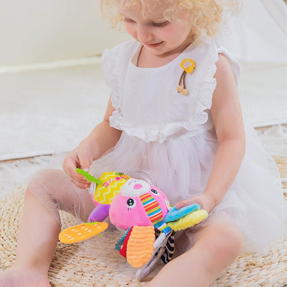Child playing with a colorful toy on a wooden floor Baby Stroller & Crib Toy Hanging Plush Sensory Animals bleu ribbon