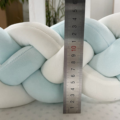 Braided pillow with a ruler for scale on a neutral background  4 Strand Nursery bleu ribbon baby