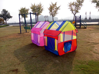 Colorful children's play tent on grass with playground equipment in the background bleu ribbon