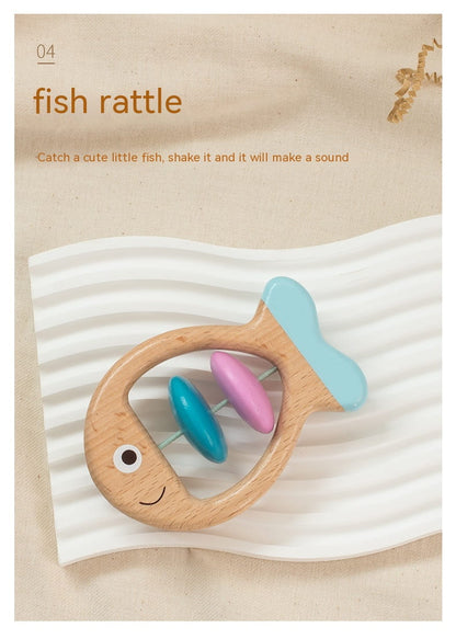 Wooden fish rattle toy with blue and pink accents on a textured beige background Montessori bleu ribbon baby