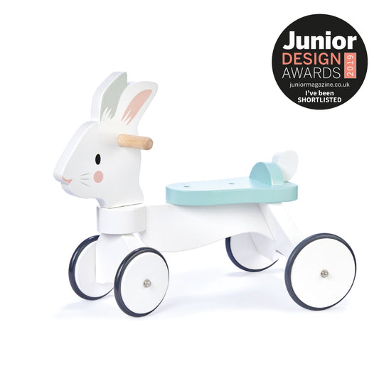 Children's toy resembling a rabbit with a tricycle, shortlisted for Junior Design Awards on a white background. Close-up of the anti-tip wheels on the Running Rabbit wooden ride-on toy.