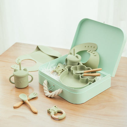 Set of green baby utensils and accessories on a wooden surface bleu ribbon baby