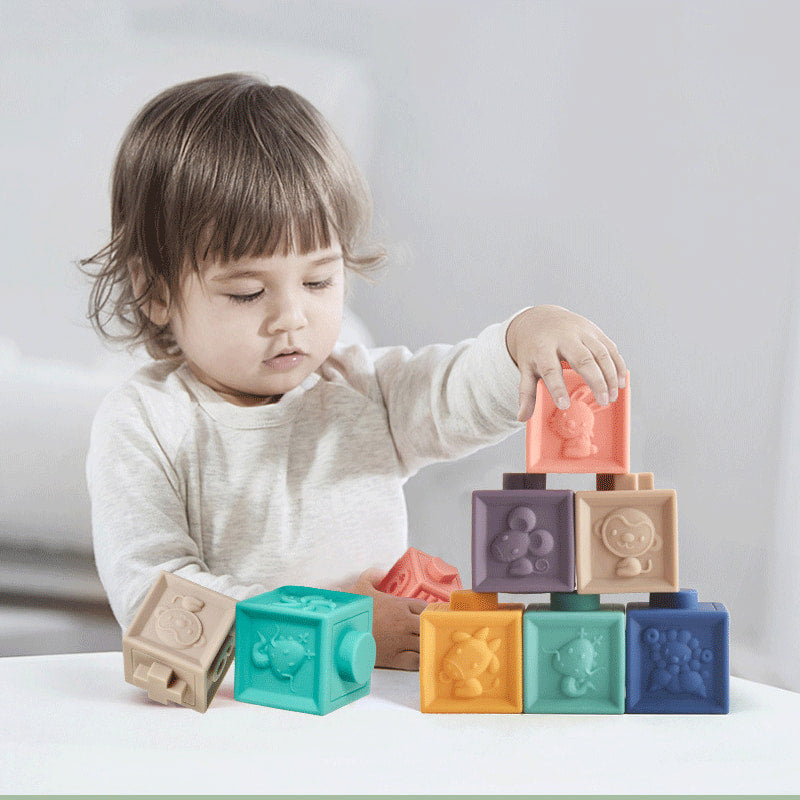 Child playing with colorful building blocks on a white surface bleu ribbon baby
