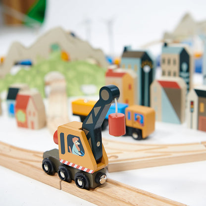 Wooden toy crane on a track with a toy town in the background Mountain View Wooden Train Set 58-piece set by Tender Leaf Toys