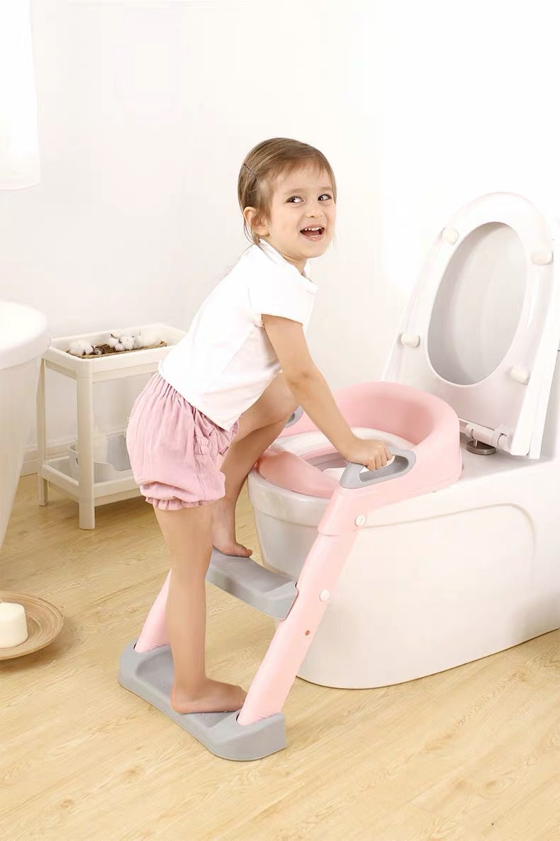 Child using a step stool to use a toilet with a pink seat cover. bleu ribbon