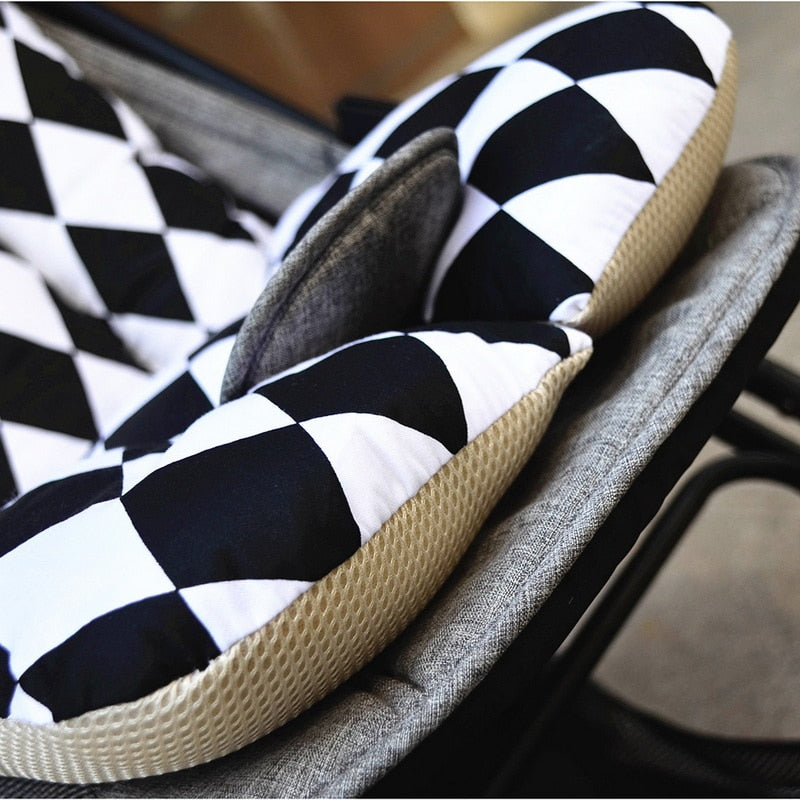Close-up of a black and white checkered cushion with a textured edge on a chair. bleu ribbon 