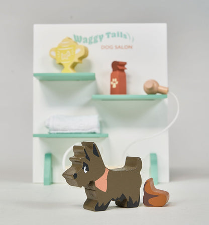 Wooden dog toy in front of a miniature dog salon set on a white background. Waggy Tails Dog Salon by Tender Leaf Toys - Wooden dog grooming set with 7 breeds