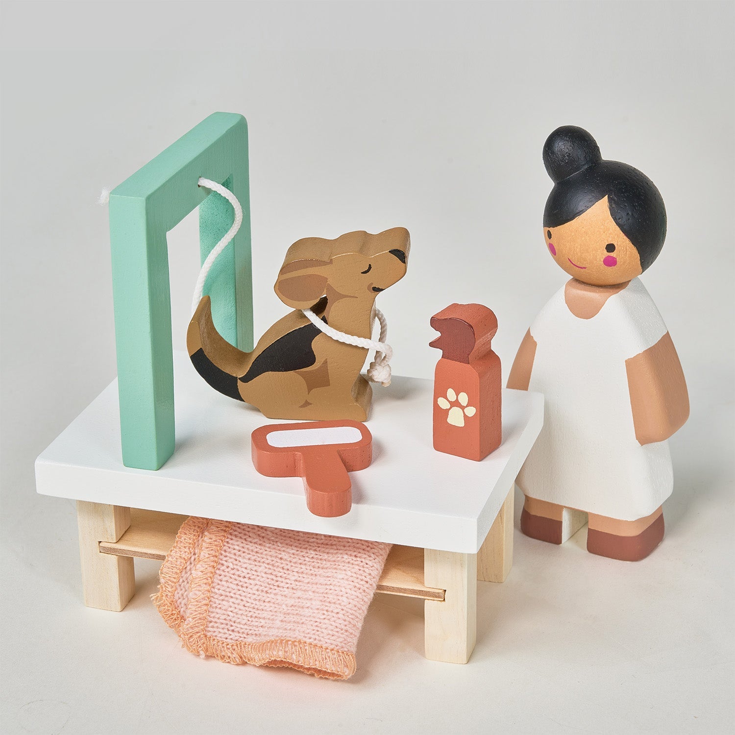 Wooden toy set with a dog, vet, and medical tools on a white background. Waggy Tails Dog Salon by Tender Leaf Toys - Wooden dog grooming set with 7 breeds