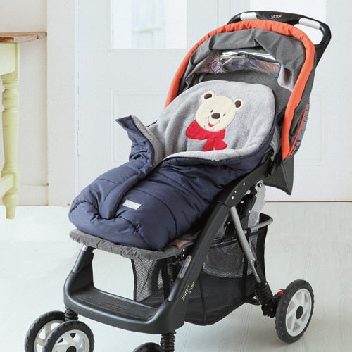 Baby stroller with a navy blue footmuff featuring a teddy bear design. bleu ribbon baby