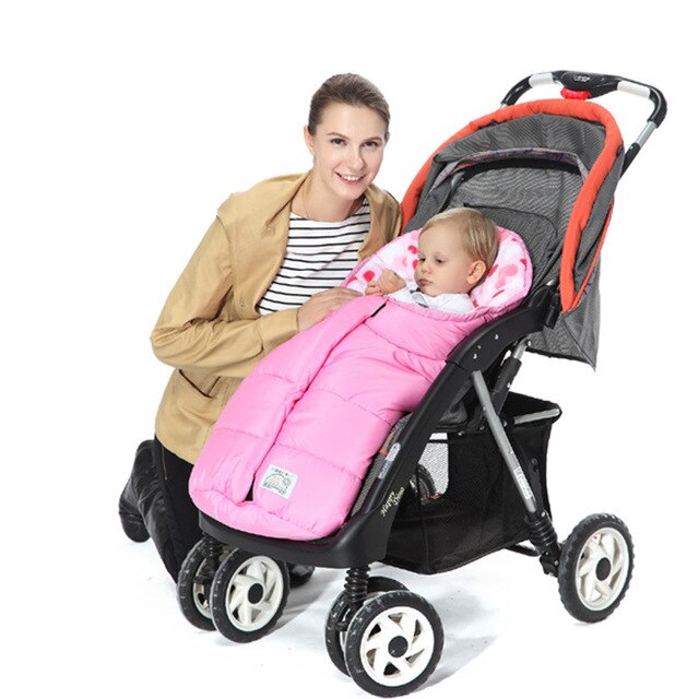 Woman holding a baby in a pink stroller cover, with a black stroller on a white background bleu ribbon baby