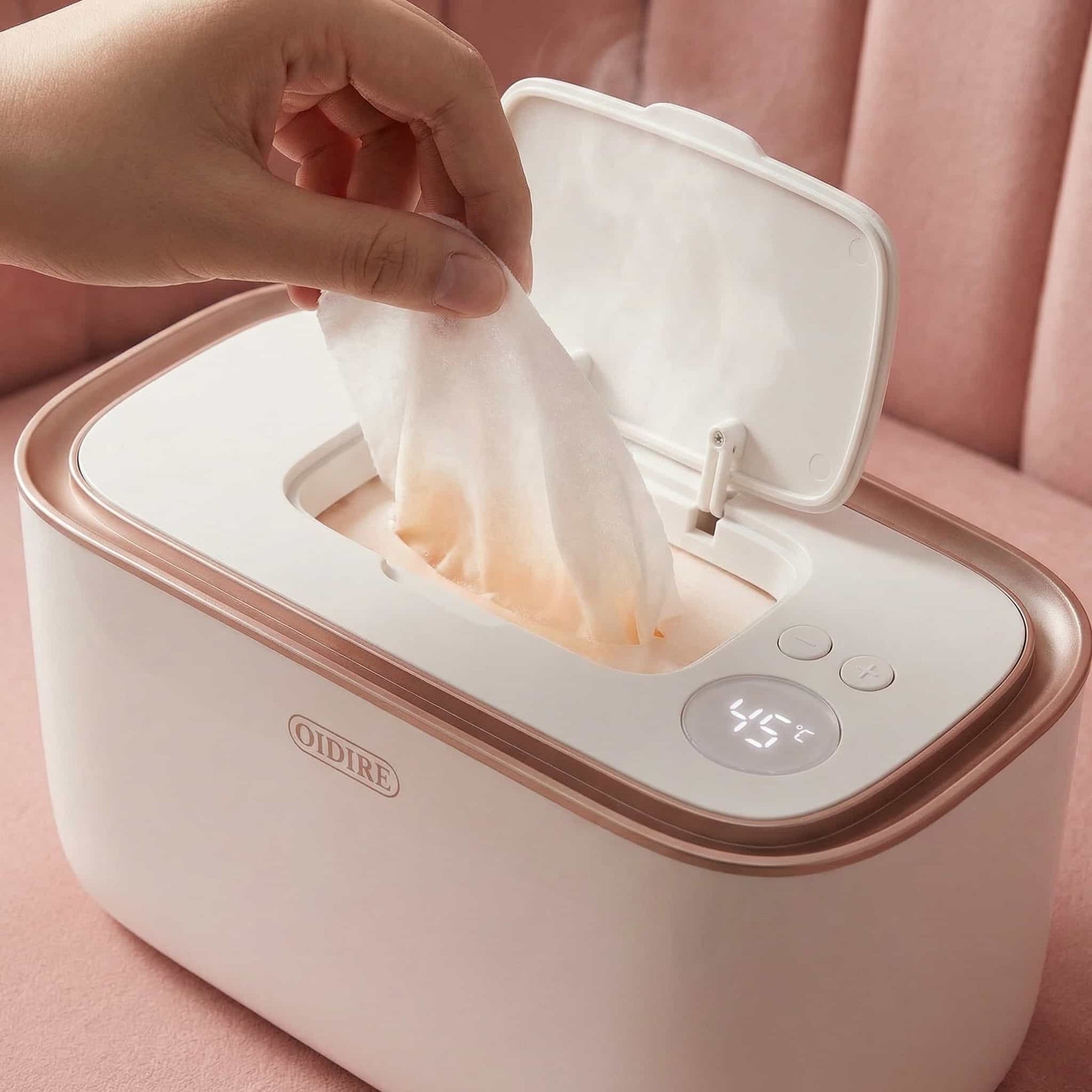 Close-up detail of the smart wipe warmer showing the digital LED temperature display and rose gold trim, highlighting the adjustable heat settings.