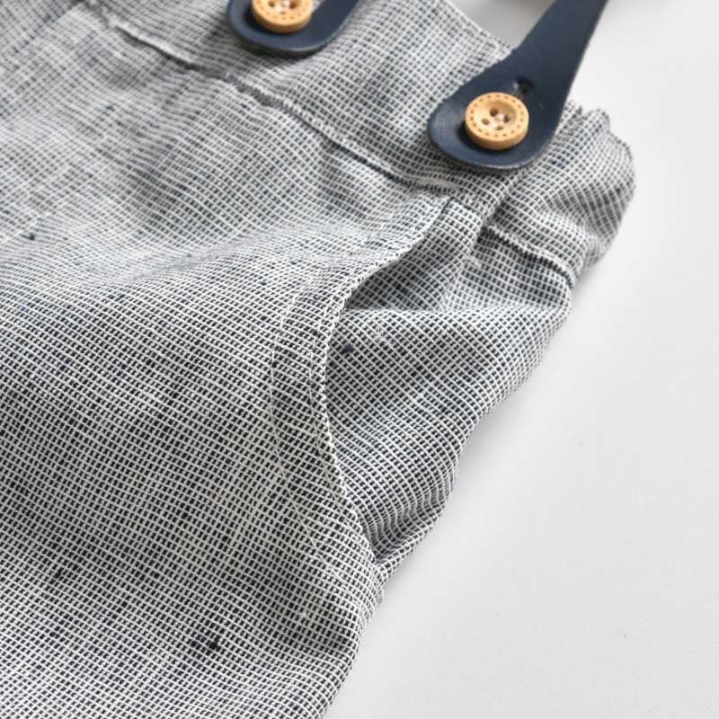 Close-up of a textured fabric with buttons on a light background bleu ribbon baby