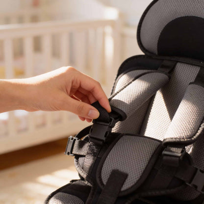 A mother gently adjusting the safety strap of the BleuRibbon portable travel seat. Easy-to-use adjustable harness system ensures secure fit for baby comfort.