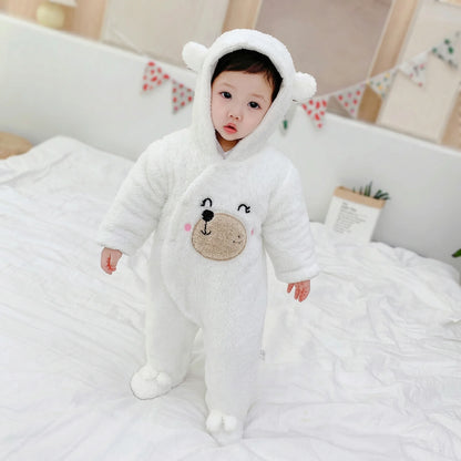 BleuRibbon Baby Winter Jumpsuit – Shu Cotton Velvet Romper​. Baby in a white bear onesie sitting on a bed