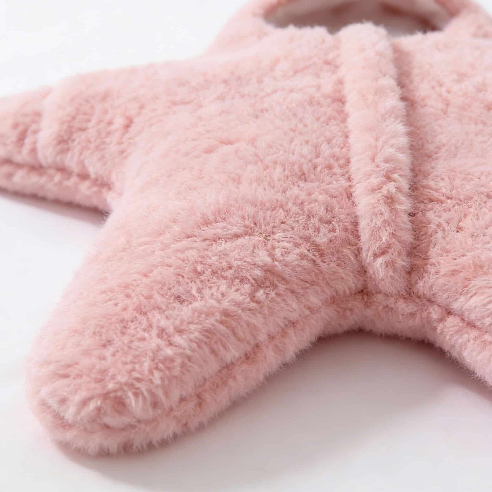Close-up of soft pink cashmere-blend fabric on BleuRibbon starfish baby suit. Thermal winter gear for newborns.