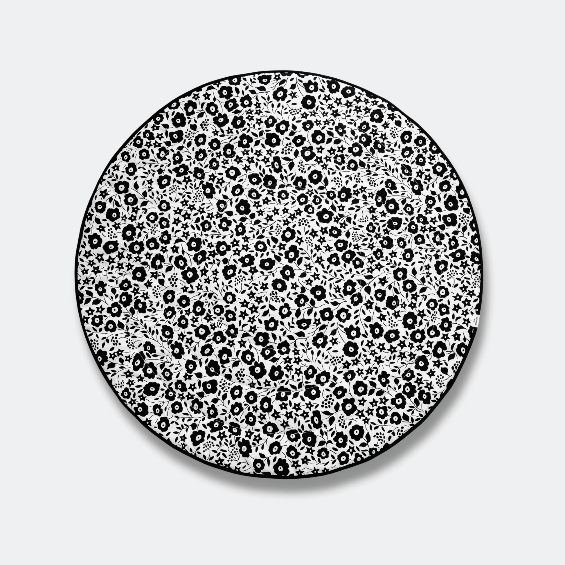 Top view of the high-contrast black and white Fairford Shadow side of the Etta Loves x Liberty round playmat, optimized for newborn visual development.