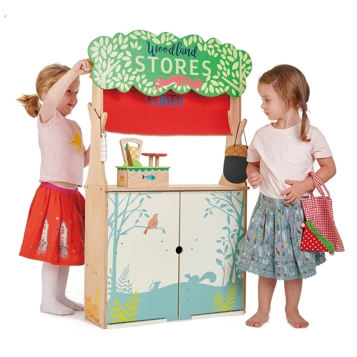 Children playing with a toy store set on a white background Puppet theatre side featuring red curtains, acorn chalkboard, and included glove puppets.