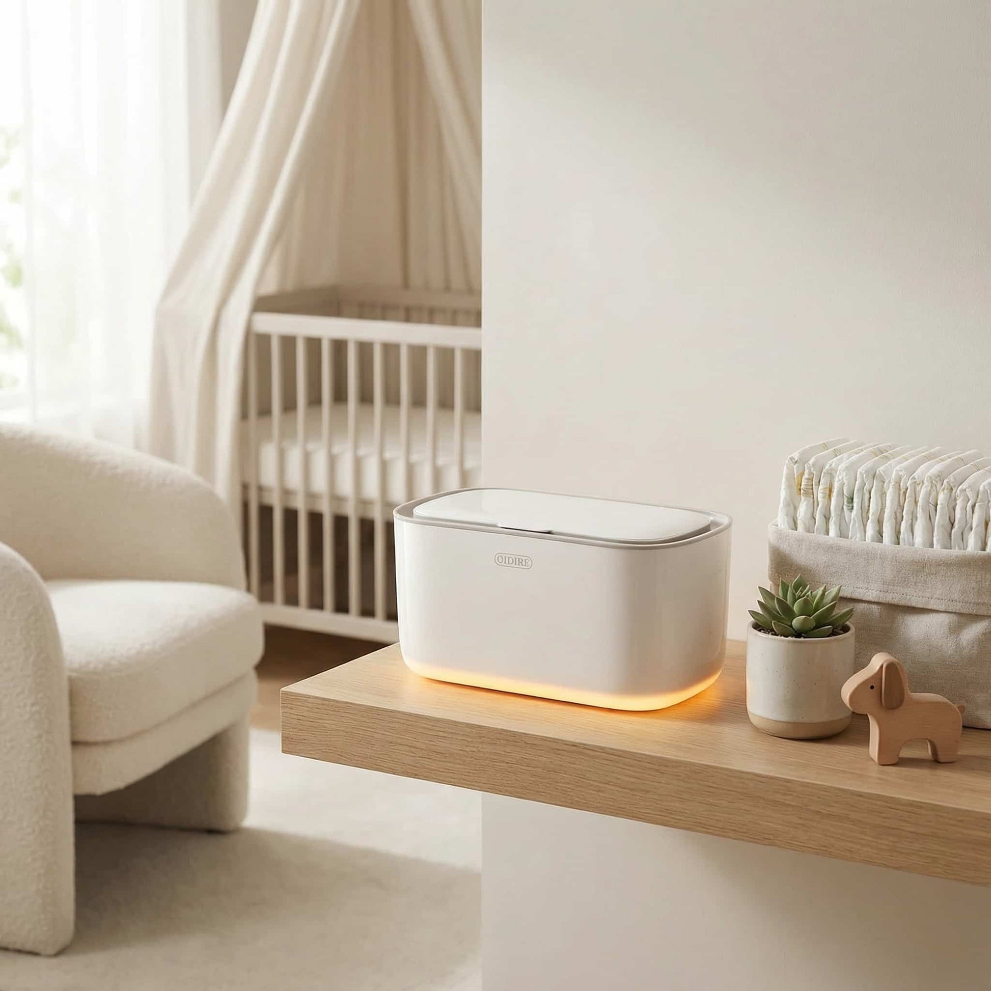 White CozyCaress adjustable wipe warmer displayed on a floating oak shelf in a neutral, modern nursery interior with organic cotton accessories.