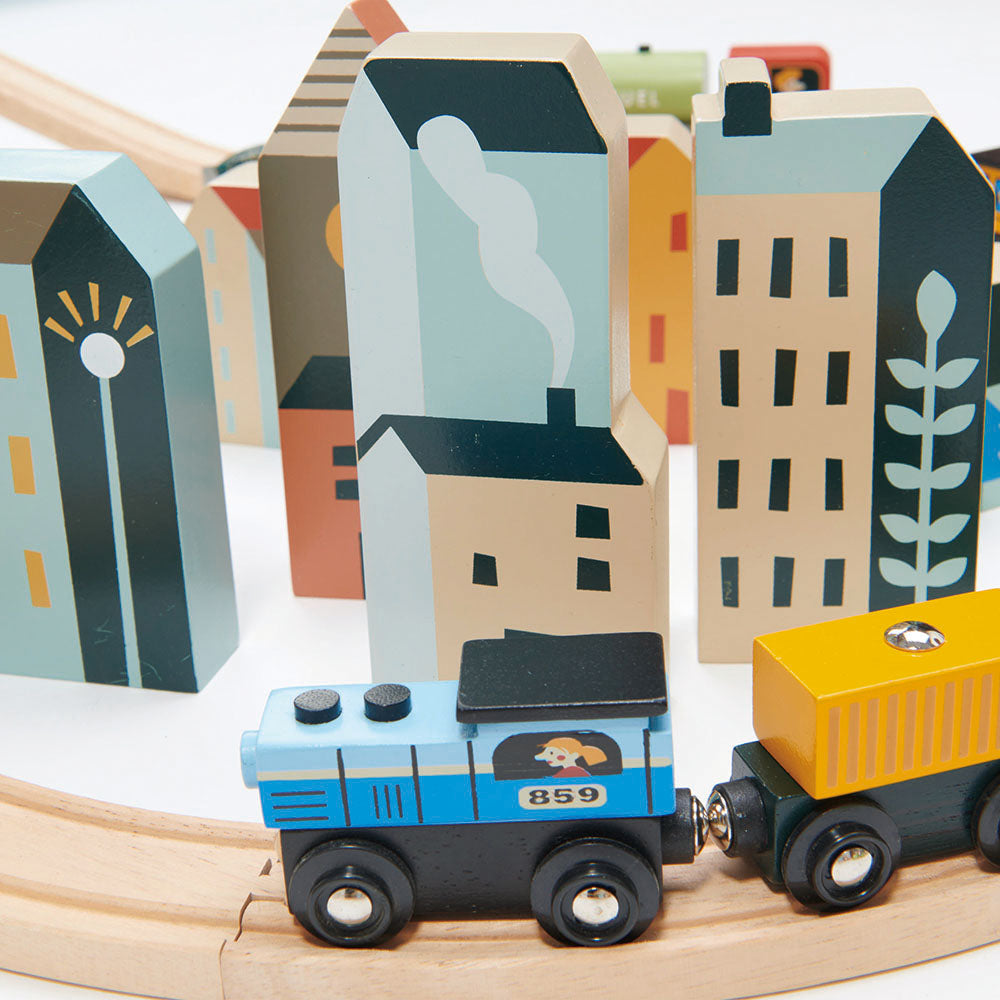Wooden toy train set on tracks with colorful buildings in the background ountain View Wooden Train Set 58-piece set by Tender Leaf Toys