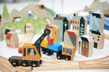 Wooden toy train set with buildings and tracks on a white surface ountain View Wooden Train Set 58-piece set by Tender Leaf Toys
