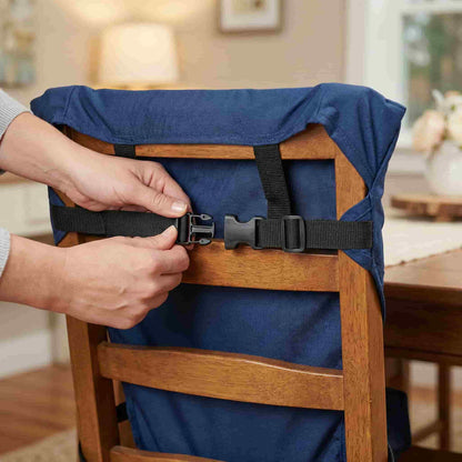 Close-up view of a parent securing the safety clips of the washable fabric high chair harness onto a standard dining chair, highlighting the strong adjustable straps.