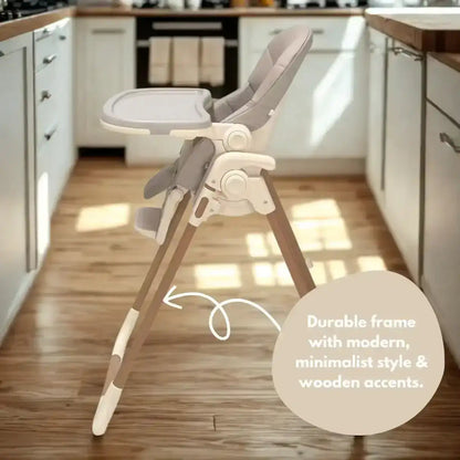 Venture Flare Highchair in Beige with adjustable height and wooden accents in a kitchen with wooden floor and white cabinets.