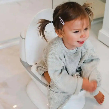 Venture Realistic Training Potty in Grey with flushing sounds and lights. Child sitting on a toilet with a white seat cover