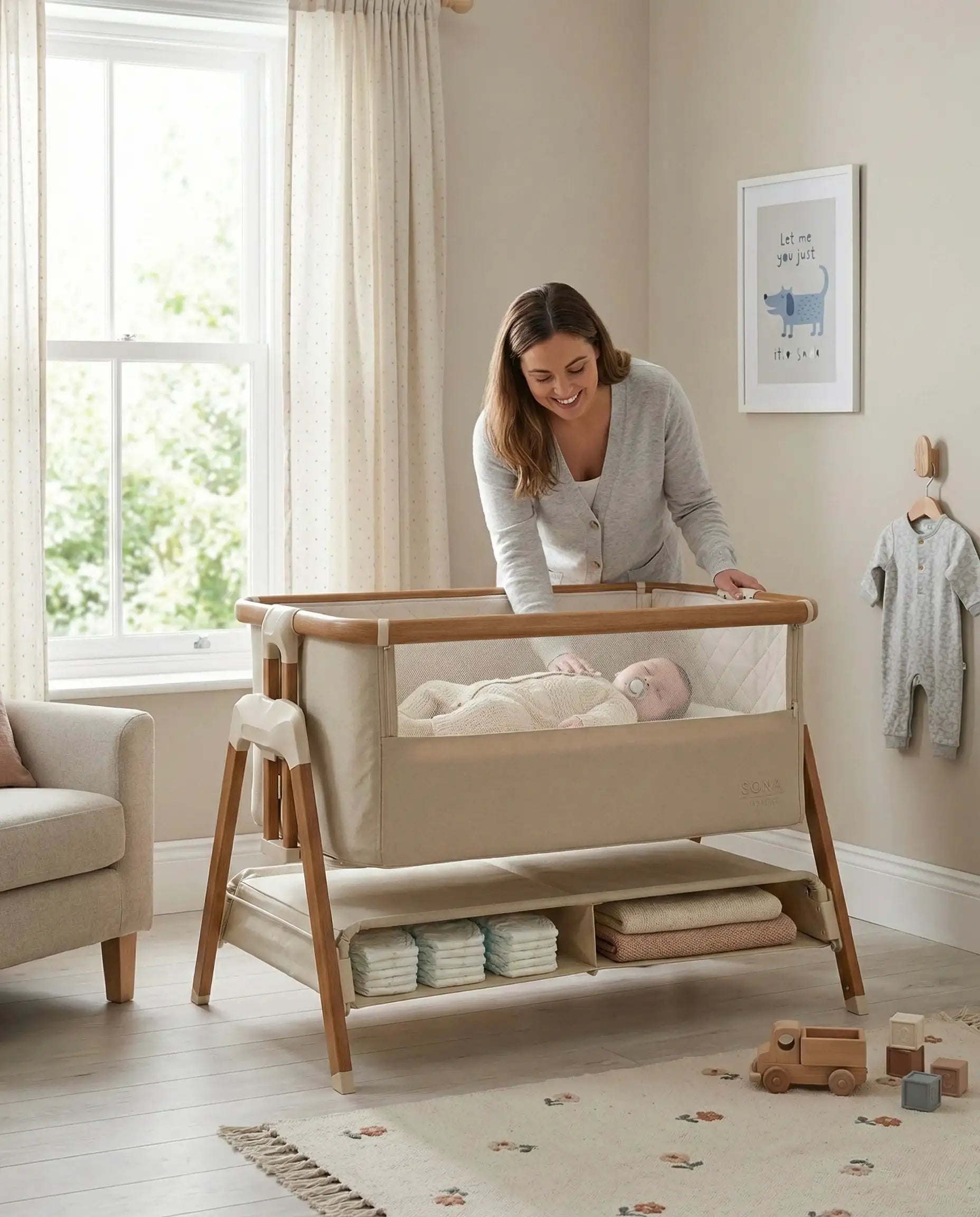 Venture Sona Bedside Crib in Beige - Safe co-sleeping crib for newborns. Woman interacting with a baby in a modern crib in a well-lit nursery.